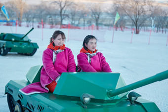 在冰天雪地玩耍雪上娱乐载具车辆的闺蜜少女