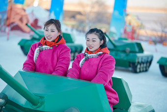 在冰天雪地玩耍雪上娱乐载具车辆的闺蜜少女