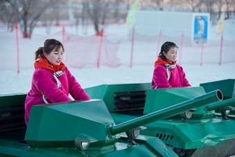 在冰天雪地玩耍雪上娱乐载具车辆的闺蜜少女