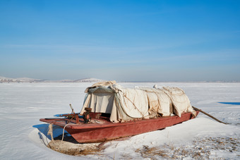 积雪覆盖的湖岸边停靠的捕鱼船