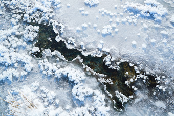 冬天野外溪水冻结冰层上的冰凌花冰松结晶