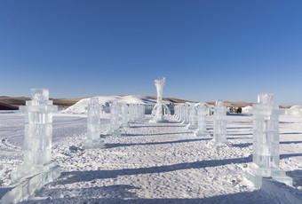 夕阳下雪原上晶莹剔透的冰雕建筑