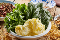 白色瓷盆装的火锅涮菜茼蒿白菜菠菜
