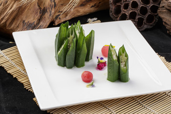 长方形瓷盘装的鲜秋葵摆放在寿司帘上