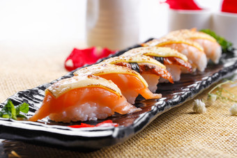 芝士焗三文鱼手握寿司摆放在草垫上