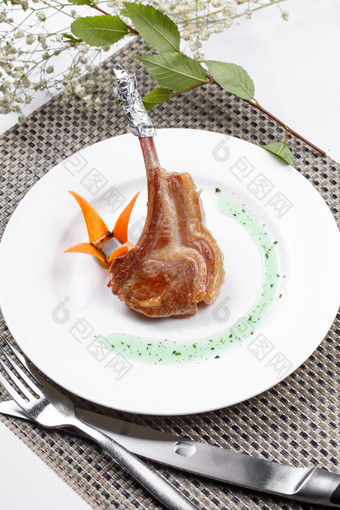 圆形白瓷盘装的波尔多法式铁板羊排摆放在餐垫上