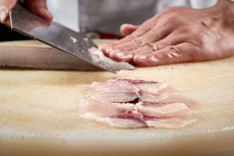 白色<strong>砧板</strong>上厨师用精湛的刀工展示生鱼片及鲜鱼料理切割分切的刀工