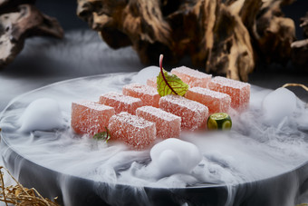 干冰缭绕的黑瓷餐具摆放的番茄糖霜<strong>江米</strong>糕