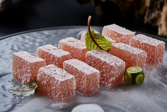 干冰缭绕的黑瓷餐具摆放的番茄糖霜<strong>江米</strong>糕
