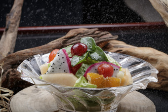 <strong>花纹玻璃</strong>碗装的果蔬拌菜摆放在樟木砧板上