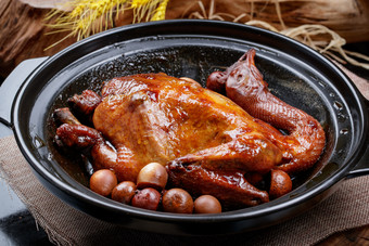 黑色砂锅装的生噘鸡煲摆放在幕布垫子上