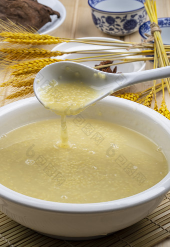 白色瓷盆装的黄金奶汤小米粥