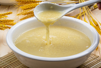白色瓷盆装的黄金奶汤小米粥