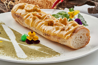白色瓷盘装的的芝士火腿焗法棍面包