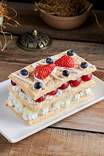 白色瓷盘装的水果戚风奶油拿破仑蛋糕