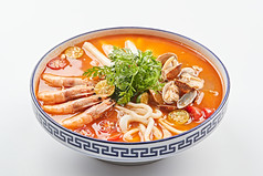 青花瓷碗装的泰式冬阴功酸辣海鲜年糕汤