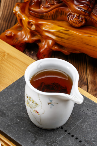 高级白瓷茶具装的沏好的<strong>普洱红茶</strong>