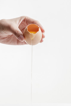 手中的开口油鸡蛋将蛋清倒出