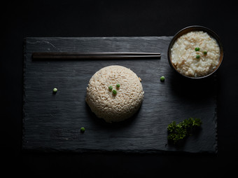 黑色青石板上摆放的燕麦米及蒸燕麦<strong>米饭</strong>