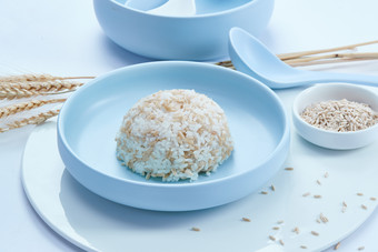 白色纸背景上的青釉瓷餐具及木质餐具装的燕麦米