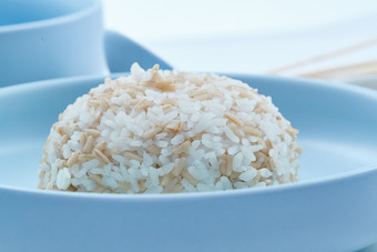 白色纸背景上的青釉瓷餐具及木质餐具装的燕麦米
