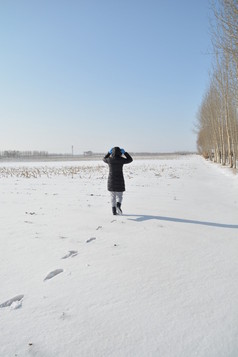 北方农村冬天在雪地上走路的女人