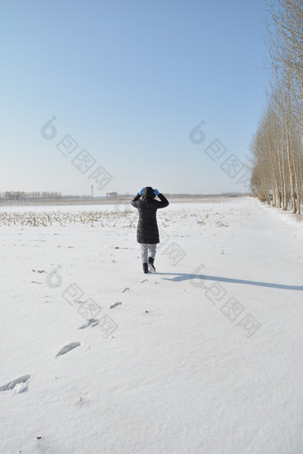 北方农村冬天在雪地上走路的女人