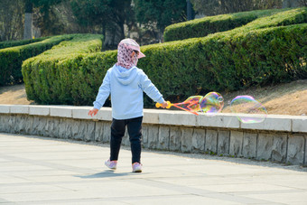 春天公园广场上玩肥皂泡的孩子