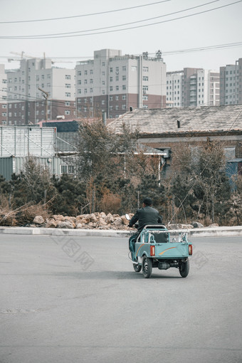 城镇街道路口骑三轮车的老人