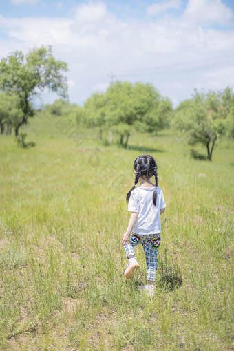 夏天行走在草地上的小女孩