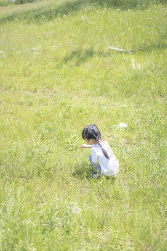 蹲在草地上的小女孩