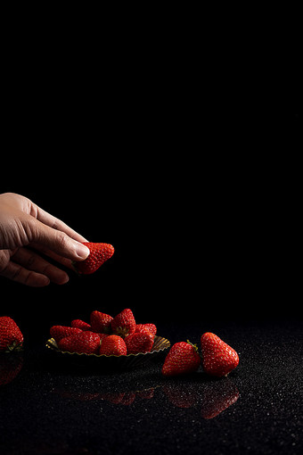 手拿水果草莓黑色背景