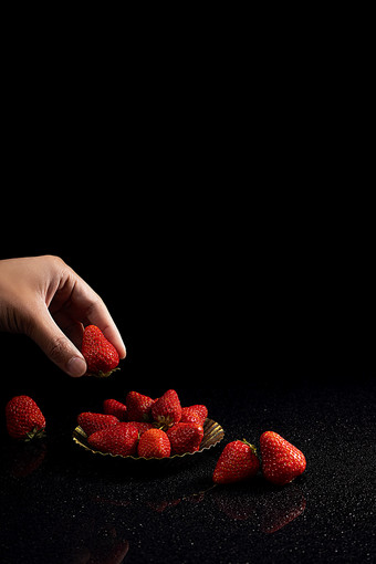 手拿草莓水果黑色背景