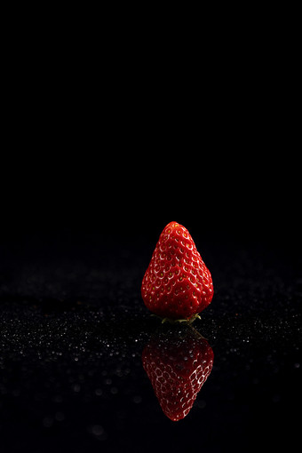 一颗草莓倒影黑色图片