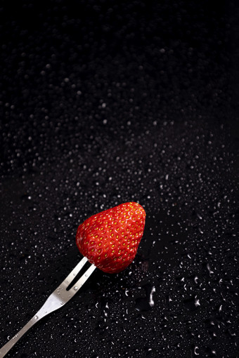 水果叉插起草莓黑色背景
