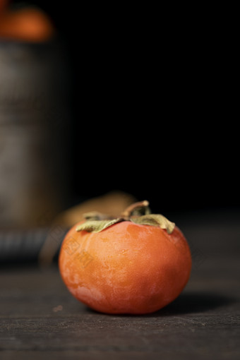 木桌上的一颗霜降柿子特写图片