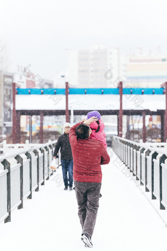 冬季抱孩子行走的路人