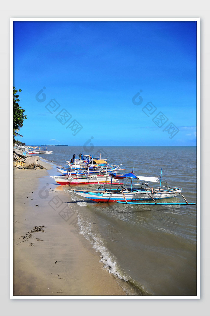 东南亚海滩港口停靠的渔船摄影图