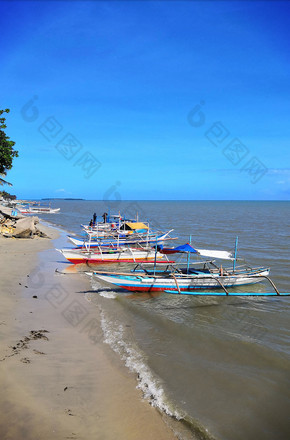 东南亚海滩港口停靠的渔船摄影图图片