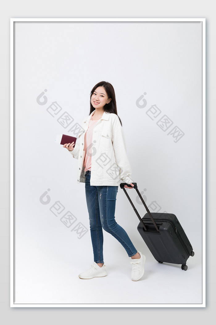 拖行李箱出发旅行的女青年摄影图片