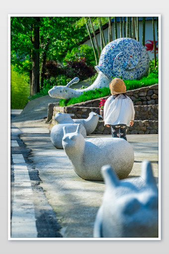 童趣蜗牛雕塑儿童背影摄影图图片