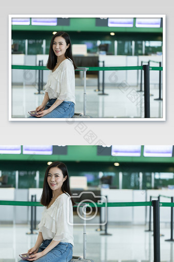 在机场坐行李箱等待值机的女性摄影图片