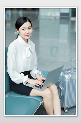 机场微笑办公使用电脑候机的职场女性