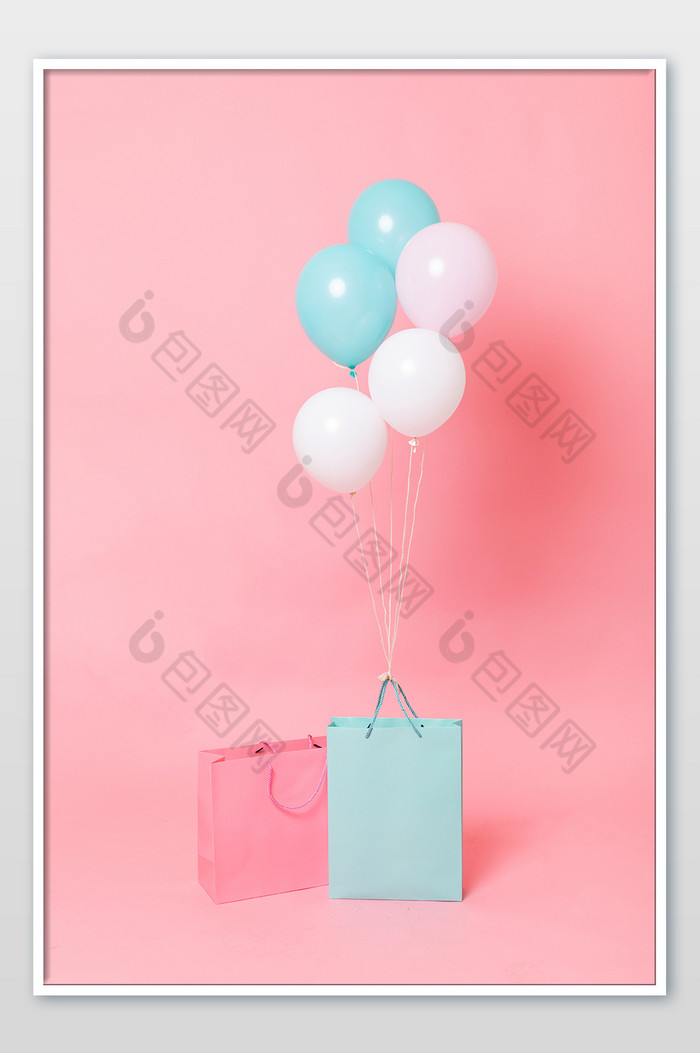 粉色背景上的购物袋和气球摄影图片图片