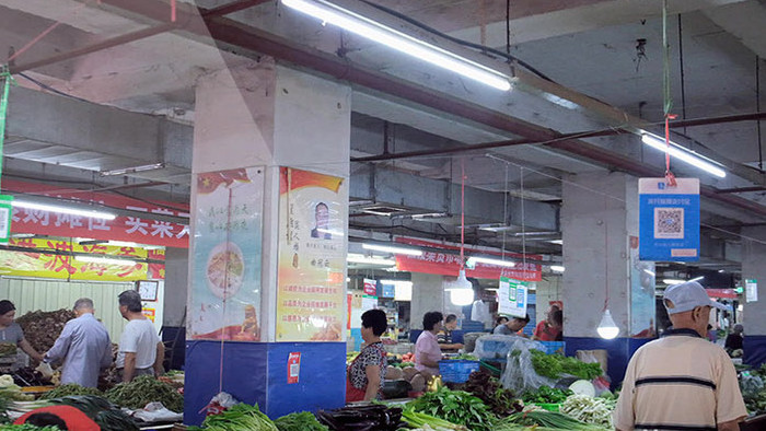 农贸市场各种蔬菜摊位和买菜的市民