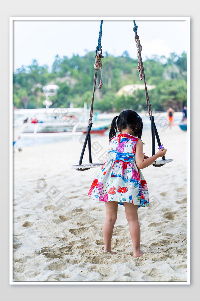 度假海滩风景儿童游玩荡秋千高清摄影图