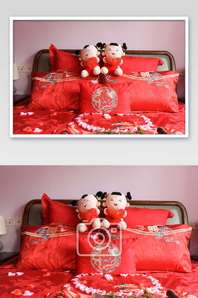 红色的床头一对小娃娃的婚床空间摄影图片