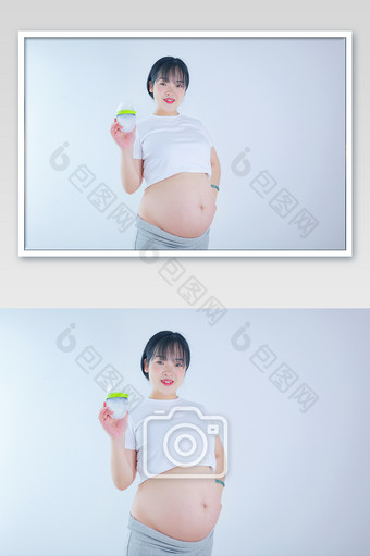 孕妇怀孕妈妈孕肚拿奶瓶摄影图片