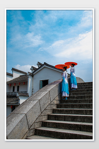 江南水乡石桥上撑油纸伞的古装美女摄影图