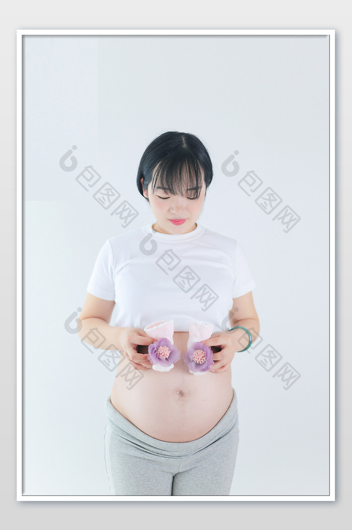 年轻孕妇孕肚怀孕举宝宝小鞋子摄影图